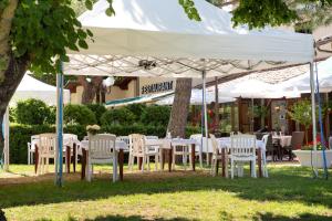 una mesa y sillas bajo un dosel blanco en Logis Hôtel et Restaurant La Bombardière, en Cuq-Toulza