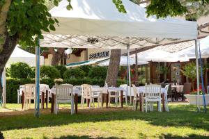 einen Tisch und Stühle unter einem weißen Baldachin in der Unterkunft Logis Hôtel et Restaurant La Bombardière in Cuq-Toulza