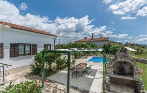 a house with a patio with an outdoor fireplace at Stunning Home In Brtonigla With Kitchen in Brtonigla