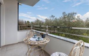 une table et des chaises sur un balcon avec vue dans l'établissement 1 Bedroom Amazing Apartment In Peroj, à Peroj