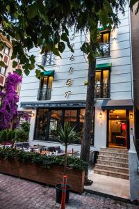 un edificio blanco con un árbol delante en Juliet Rooms & Kitchen, en Estambul