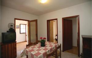 a dining room with a table with a vase of flowers on it at Awesome Apartment In Labin With Wifi in Raša