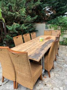 a wooden table with wicker chairs and a wooden table at Uniquely Private Holiday Villa in the Charente in Puyréaux