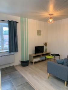 a living room with a couch and a tv at Le moulin des 2 roues in Meung-sur-Loire