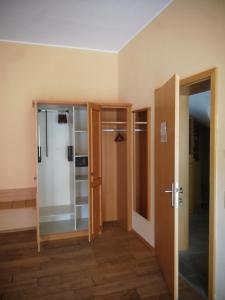 um quarto vazio com uma porta e um frigorífico em Gästehaus Reßler em Harxheim