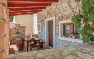 a patio with a table and a stone building at Beautiful Home In Liznjan With Ethernet Internet in Ližnjan