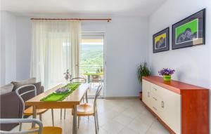 a kitchen and dining room with a table and chairs at Amazing Apartment In Labin With Kitchen in Hrvatini