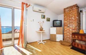 uma sala de estar com uma televisão e uma parede de tijolos em Stunning Apartment In Karlobag With Wifi em Barić Draga