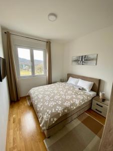 - une chambre avec un grand lit et une fenêtre dans l'établissement NEWTOWN APARTMENT, à Nikšić
