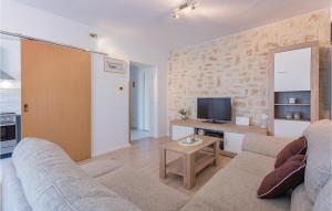 a living room with a couch and a tv at Beautiful Apartment In Fazana With Kitchen in Fažana