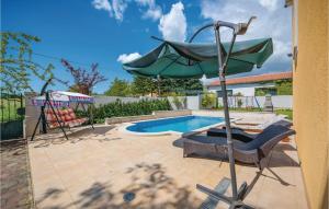 a patio with a table and an umbrella next to a pool at Holiday Home Mlaginje Iii in Žminj +29 photos