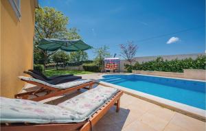 a swimming pool with two lounge chairs and an umbrella at Holiday Home Mlaginje Iii in Žminj