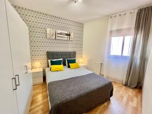 1 dormitorio con 1 cama con 2 almohadas amarillas en Comfortable renovated flat, WiFi! en Badalona