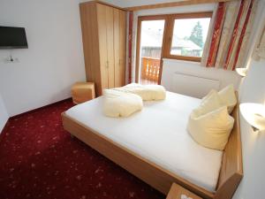 a bedroom with a bed with white sheets and pillows at Apartment Uderns near Hochzillertal Ski Lift in Uderns