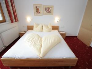 a bedroom with a bed with white sheets and pillows at Apartment Uderns near Hochzillertal Ski Lift in Uderns