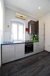cocina con armarios blancos, fregadero y ventana en A2 - apartment in the very heart of Split en Split