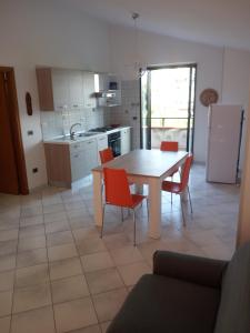 uma cozinha com uma mesa e cadeiras vermelhas num quarto em Sant'Andreas house em Santa Maria di Castellabate