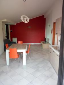 uma cozinha e sala de jantar com uma mesa e cadeiras laranja em Sant'Andreas house em Santa Maria di Castellabate