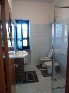 uma casa de banho com um WC, um lavatório e um chuveiro em Sant'Andreas house em Santa Maria di Castellabate