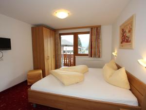 ウダーンスにあるStylish Apartment in Uderns with Balconyのベッドルーム1室(白いシーツ付きのベッド1台、窓付)