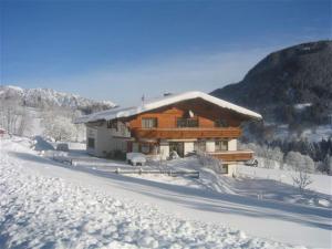 een blokhut in de sneeuw met een berg bij Cozy holiday apartment with sauna in Schladming in Schladming