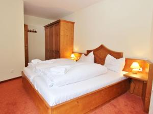 1 dormitorio con 1 cama grande con sábanas blancas en Chalet apartment in Saalbach Hinterglemm en Saalbach Hinterglemm