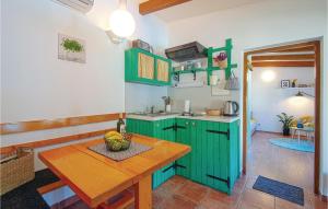 a kitchen with green cabinets and a wooden table at Amazing Home In Lopatinec With Jacuzzi in Lopatinec
