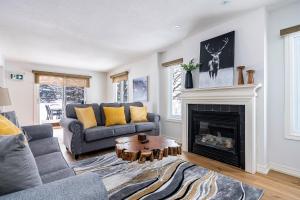 a living room with a couch and a fireplace at Luxurious Blue Mountain 3BR & 3BTH Walk-in to Village in Blue Mountains