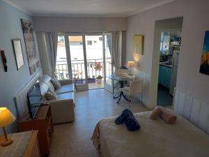 a bedroom with two beds and a living room with a balcony at DESCANSO IDEAL II CABO CORRIENTES in Mar del Plata
