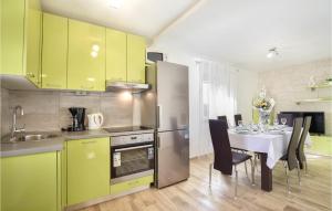 una cocina con armarios amarillos y una mesa con sillas en 4 Bedroom Cozy Home In Brstanovo, en Brštanovo