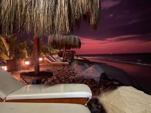 - une plage avec des chaises, un parasol et l'océan dans l'établissement El Samay Hotel Boutique, à Canoas de Punta Sal