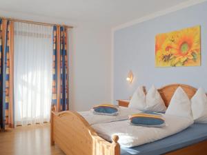 a bedroom with a wooden bed with two pillows on it at Lovely Apartment with Terrace in F genberg in Fügen