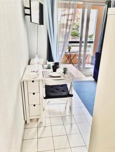 Un pequeño escritorio blanco en una habitación con ventana en Azzurra, en Beausoleil