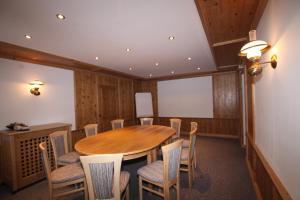 einen Konferenzraum mit einem Holztisch und Stühlen in der Unterkunft Gasthof zur Mühle in Leutasch