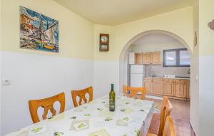 a dining room with a table and a kitchen at Awesome Home In Malinska With Outdoor Swimming Pool in Gostinjac