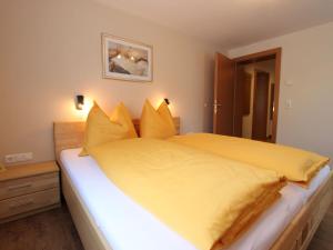 a bedroom with a large yellow bed with yellow pillows at Spacious Apartment in Kleinarl near Ski Lift in Kleinarl