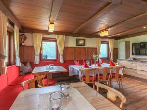 comedor con mesas, sillas y paredes rojas en Rustic country house in Mittersill near ski area, en Mittersill