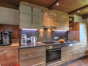 cocina con armarios de madera y horno con fogones en Rustic country house in Mittersill near ski area, en Mittersill