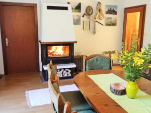 une salle à manger avec une table et une cheminée dans l'établissement Holiday apartment in Ferlach near Woerthersee, à Oreinschnak