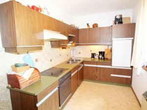 a kitchen with wooden cabinets and a counter top at Holiday apartment in Ferlach near Woerthersee in Oreinschnak