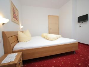 ウダーンスにあるCharming Apartment in Uderns with Balconyのベッドルーム(白いシーツ付きのベッド、テレビ付)