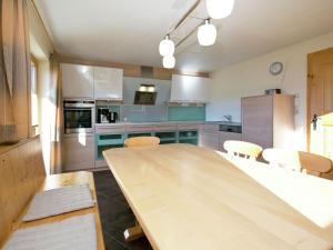 a kitchen with a wooden table and chairs at Chalet in Hopfgarten in Brixental with hot tub in Hopfgarten im Brixental