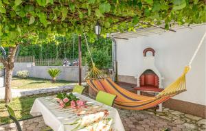 patio z hamakiem i stołem z kwiatami w obiekcie 3 Bedroom Beautiful Home In Labin w mieście Labin