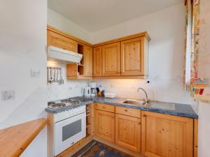 a small kitchen with wooden cabinets and a sink at Spacious Apartment in Afritz am See near Ski Area in Afritz