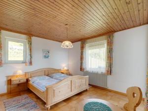 アフリッツにあるSpacious Apartment in Afritz am See near Ski Areaの木製の天井が特徴のベッドルーム1室(ベッド1台付)