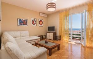 a living room with a white couch and a table at 2 Bedroom Lovely Apartment In Rabac in Raša
