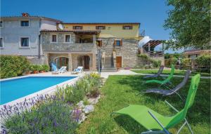 a house with a swimming pool and green lawn chairs at Stunning Home In Krsan With 4 Bedrooms, Wifi And Outdoor Swimming Pool in Kršan