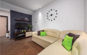 a living room with a couch and a clock on the wall at Stunning Home In Labin With Jacuzzi in Koromačno