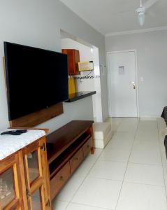 Uma TV ou centro de entretenimento em Apartamento Praia Grande Vila Caiçara