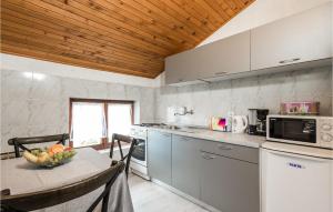 a kitchen with a table with a bowl of fruit on it at Stunning Apartment In Rukavac With 2 Bedrooms, Wifi And Outdoor Swimming Pool in Rukavac